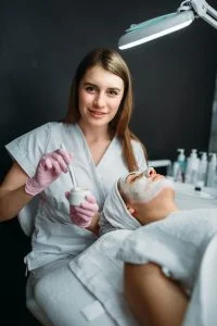 female doctor holds cream and brush in hands 200x300 1